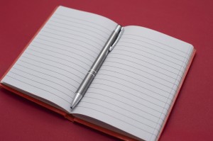 Open notebook with a ballpoint pen in the center