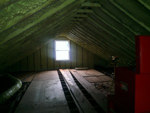 Mostly empty attic. The green in the ceiling is spray foam insulation and you can see old duct work and the loose boards that served as a floor.